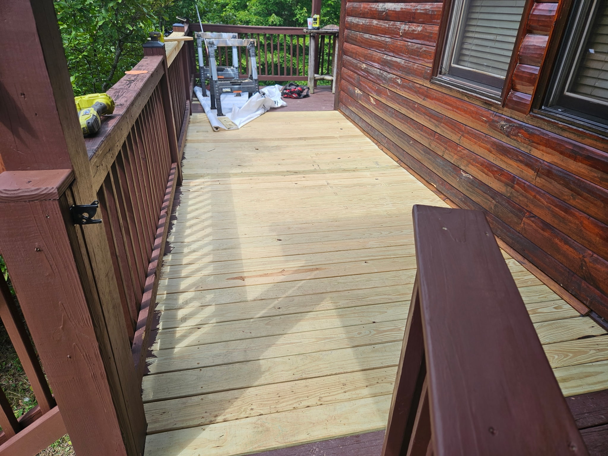 New pressure-treated deck boards being installed